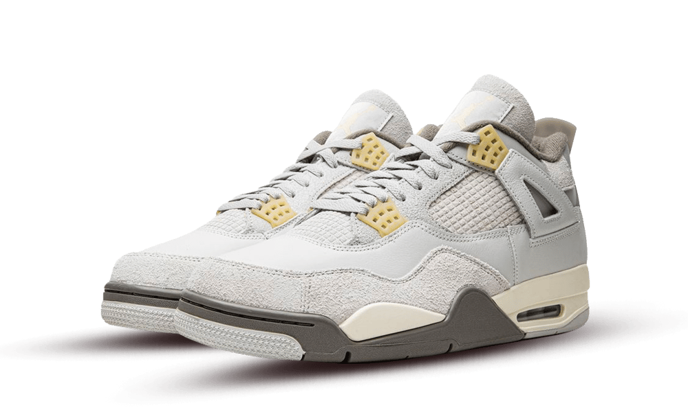 Paire de Jordan 4 grises à détails jaune pâle, vue de trois quarts