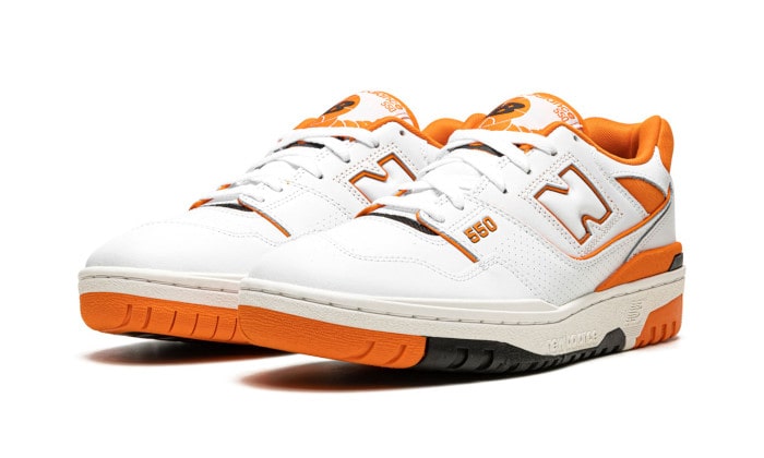 Paire de New Balance 550 Syracuse blanches et orange vue de trois quarts